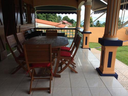 a table and chairs on the porch of a house at villa sofaia Guadeloupe in Sainte-Rose