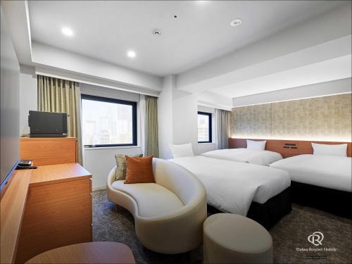 a hotel room with two beds and a tv at Daiwa Roynet Hotel Yokohama-Koen in Yokohama