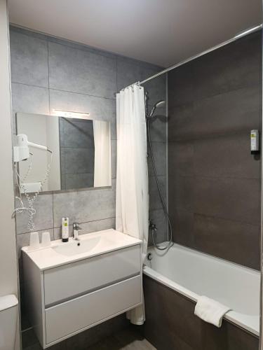 a bathroom with a sink and a tub and a shower at Logis Hôtel Le Saint Clément in Saint-Clement-sur-Valsonne