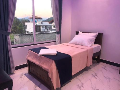 a purple bedroom with a bed and a window at Sevmeth Villa in Kandy