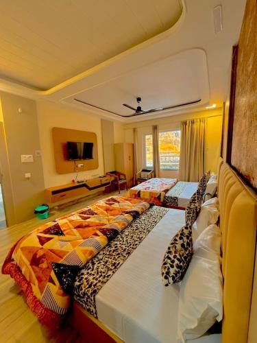 a room with three beds with pillows on them at The Kridha Palace in Ayodhya