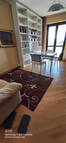 a living room with a table and chairs and a rug at I sogni di viola in Saluzzo