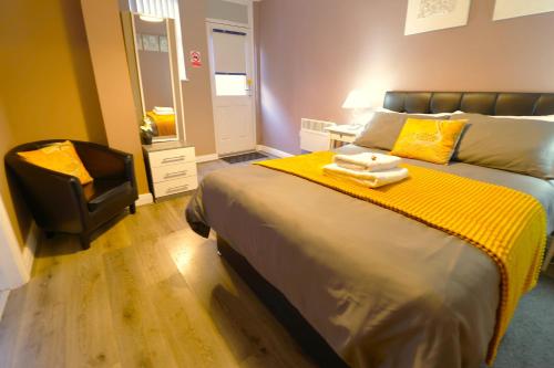 a bedroom with a bed with a yellow blanket and a chair at Modern 1 Bedroom Apartment Free Parking WiFi Near City Centre in Leeds
