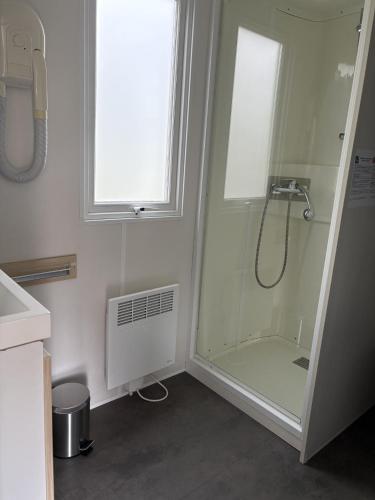 a bathroom with a shower and a window at camping de la mottelette in Forest-Montiers