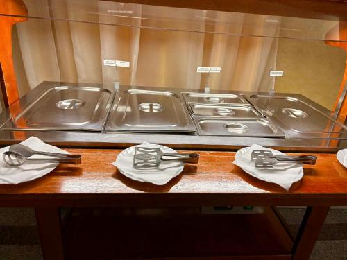 a counter with three sinks and napkins on a table at Hotel Emma Est in Craiova