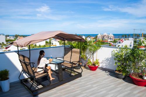 a woman sitting in a chair on a roof at Hanah Hotel Phan Thiet in Phan Thiet