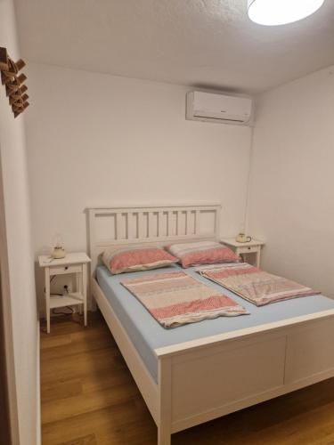 a bedroom with a bed with two pillows on it at Holiday Home Roza in Mirce