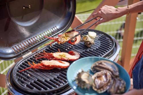 a person is cooking food on a grill at Solana 鴨川 in Kamogawa