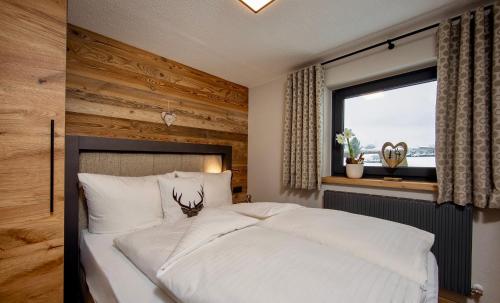 a bedroom with a large white bed with a window at Alpenchalet am Lech in Ehenbichl