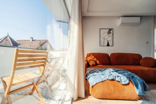 a living room with a couch and a chair at Zara Garden Apartment in Novi Sad