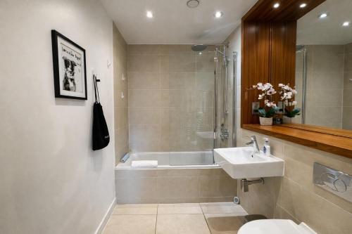 a bathroom with a sink and a tub and a toilet at FruitTrees Serviced Apartment in Cambridge