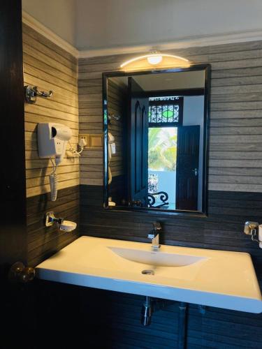 a bathroom with a sink and a mirror at The Villa Hotel in Unawatuna