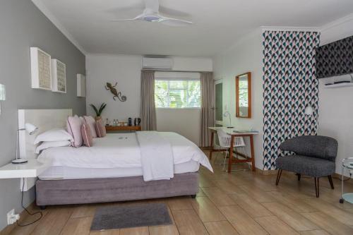 a bedroom with a bed and a desk and a chair at Ballinderry, The Robertson Guest House in Robertson