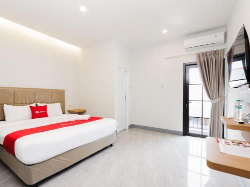 a bedroom with a large bed and a window at RedDoorz Plus Ciapus Bogor in Cimanglid