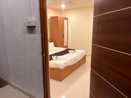 ein kleines Zimmer mit einem Bett und einem Spiegel in der Unterkunft Siya dormitory and rooms in Kolhapur