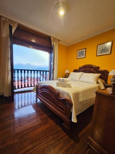 a bedroom with a bed with a view of a balcony at Casa Villadam in Ribadesella