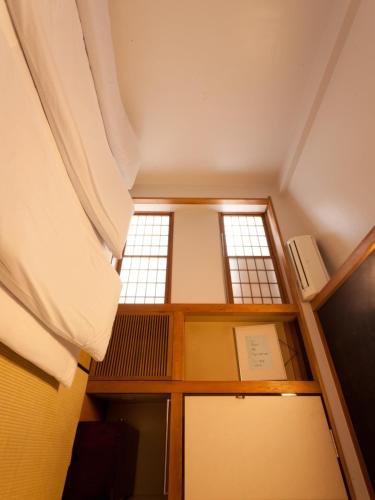 an attic room with a window and a book shelf at Kimi Ryokan in Tokyo