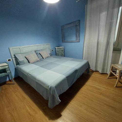 a blue bedroom with a large bed with blue walls at La casina di Silverio in Rio Marina