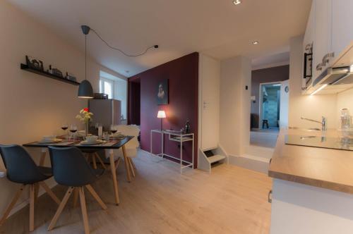 een keuken en een woonkamer met een tafel en stoelen bij Gästehaus Vanille & Chocolat in Stolberg