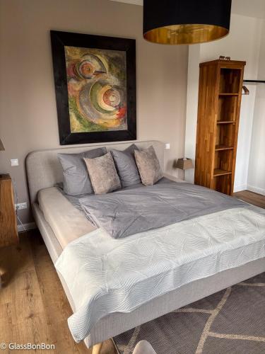 a bed in a bedroom with a painting on the wall at Altstadtflair - Ruppin Quartier Stadtmitte in Neuruppin