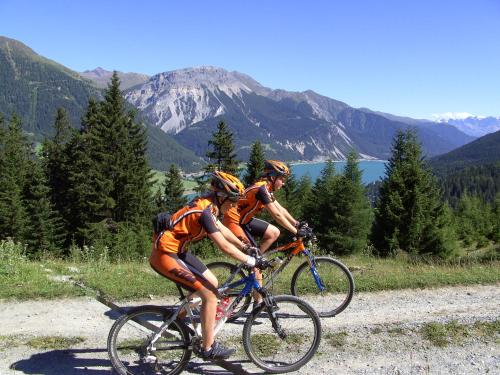 two people riding bikes on a mountain road at Apart Claudia in Nauders