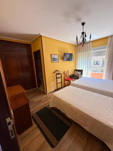 a bedroom with a large bed and a chair at La Calma Candás in Candás