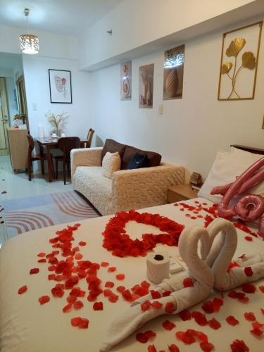 a bed with red roses and hearts on it at Spacious Studio Davao in Davao City