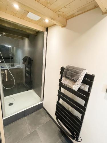 a bathroom with a shower and a towel on a chair at Le Chalet aux Biches in Bolquere Pyrenees 2000