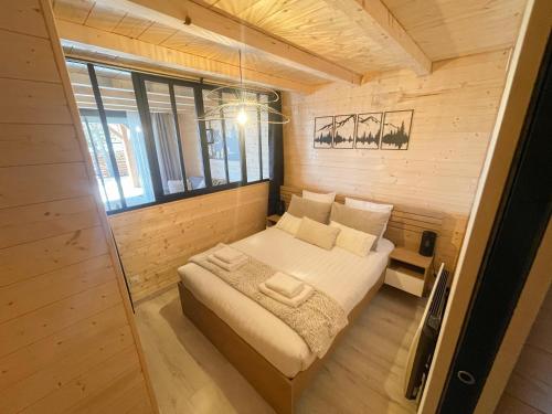a small bedroom with a bed in a wooden room at Le Chalet aux Biches in Bolquere Pyrenees 2000