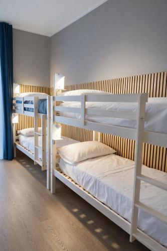 two bunk beds in a room with white bunkresses at BEDS&ROOMS TIBURTINA - Beds, Posti letto in Rome