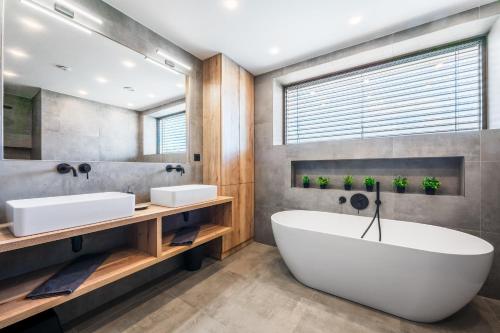 a bathroom with two sinks and a large tub at Villa K&L Pasohlávky in Pasohlávky
