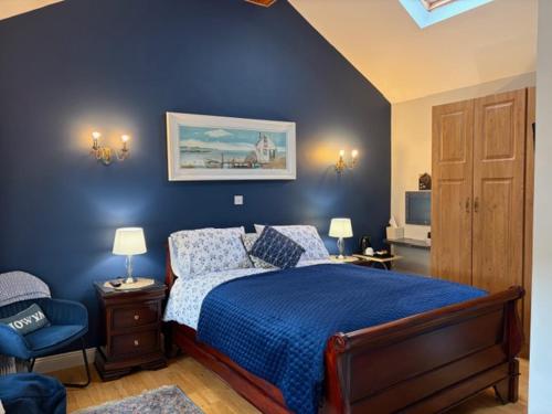 a blue bedroom with a bed and a chair at Tess's Guest House R95K6N1 This Property is unsuitable for children under 12 years old in Freshford