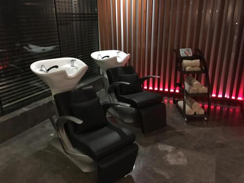 a bathroom with a sink and two chairs and a bath tub at Radisson Blu Hotel MBD Ludhiana in Ludhiana