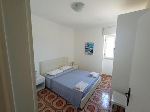 a bedroom with a bed with two towels on it at Mamalina Residence in Torre Pali