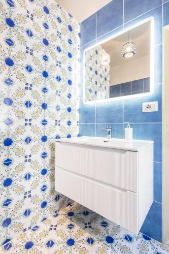a bathroom with a white sink and blue and white tiles at Residence Mareluna - Amalfi Coast by Mareluna Hotel in Vietri sul Mare