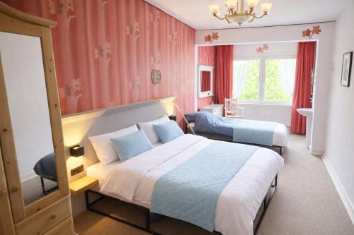 a hotel room with two beds and a window at Das blaue Haus - Huize Hubertus in Sankt Andreasberg