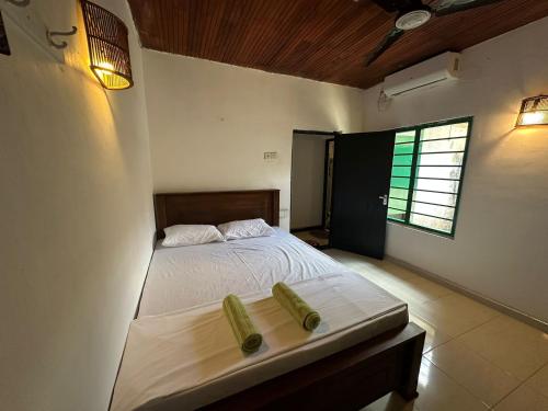 a bedroom with a bed with two pillows on it at Jungle Flower Town in Matara