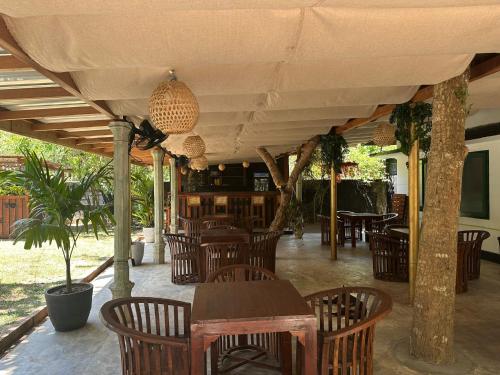 a patio with wooden chairs and tables and a table at Jungle Flower Town in Matara
