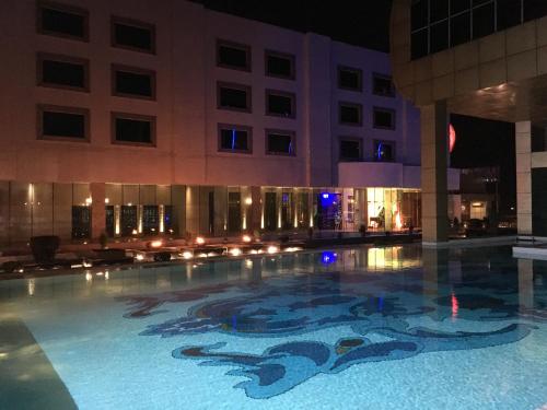 ein Schwimmbad in einem Gebäude in der Nacht in der Unterkunft Radisson Blu Hotel MBD Ludhiana in Ludhiana