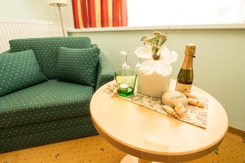 a couch and a table with a bottle of champagne at Hotel Alpina nature-wellness in Wenns