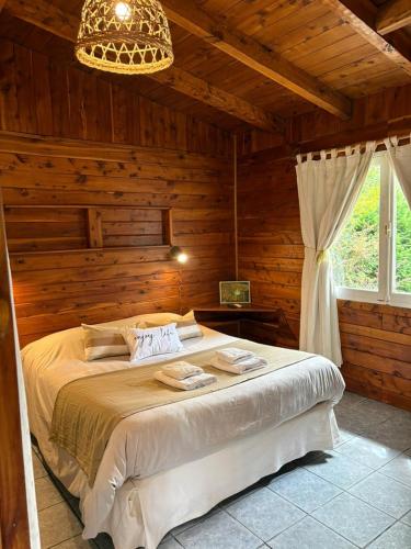 a bedroom with a bed in a log cabin at Cabañas Walnor in Villa Traful