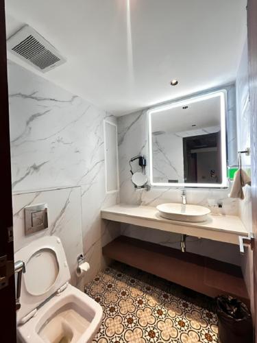 a bathroom with a toilet and a sink and a mirror at Emerald Luxe A Boutique Hotel Chandigarh Mohali in Mohali