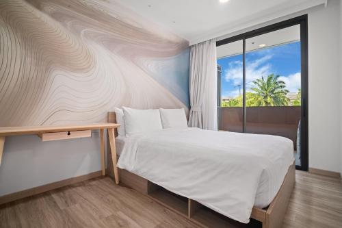 a bedroom with a white bed and a window at Skypark Aurora in Laguna by Banyan Living in Thalang