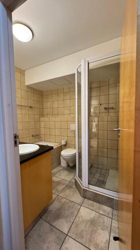 a bathroom with a shower and a toilet and a sink at Hibernian Towers 1503 in Strand