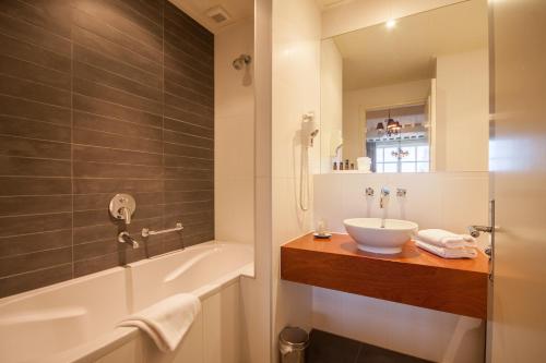 a bathroom with a sink and a bath tub at Auberge de Campveerse Toren in Veere