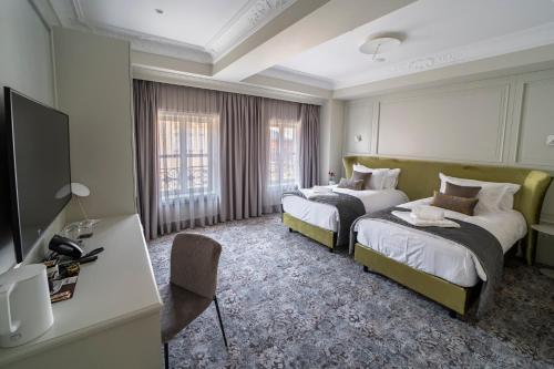a hotel room with two beds and a flat screen tv at VIZUALIZA Residence Hotel by HMG in Plovdiv