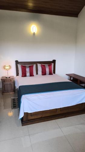a bedroom with a large bed with red pillows at City Breeze Residence in Kandy