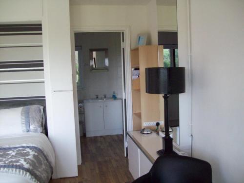 a bedroom with a bed and a desk with a lamp at WILLOW BARN boutique B&B in Worle