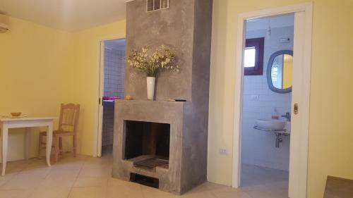 a living room with a fireplace and a sink at Borgo degli Ulivi Depandance in Capoterra