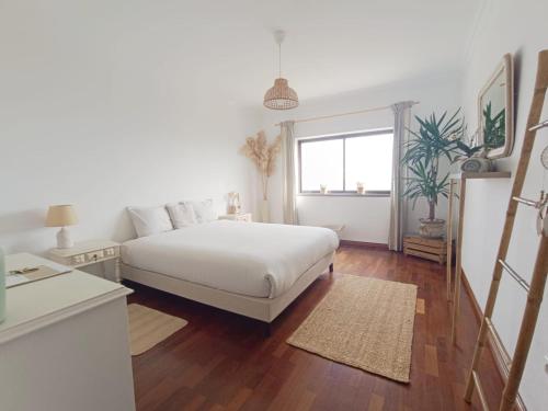 a white bedroom with a bed and a window at Villa Intuitiva - Relaxation and Mindful Stay in Lourinhã
